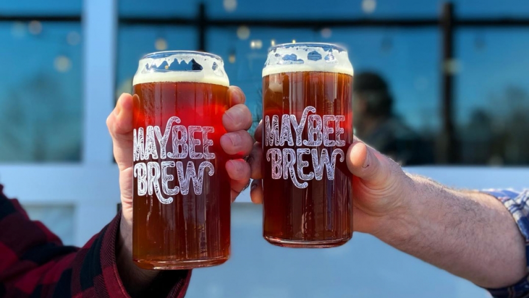 maybee brewery glasses fill with beer and two hands toasting
