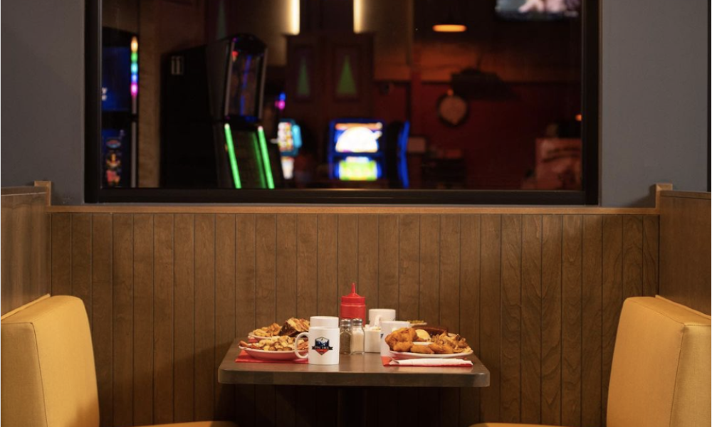 a diner booth with yellow coloured seats and a table with food